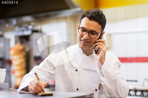 Image of chef at kebab shop calling on smartphone