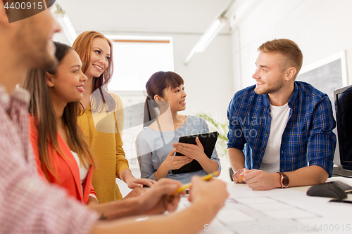 Image of creative team with blueprint working at office