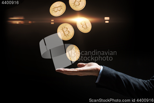 Image of close up of businessman hand with bitcoins