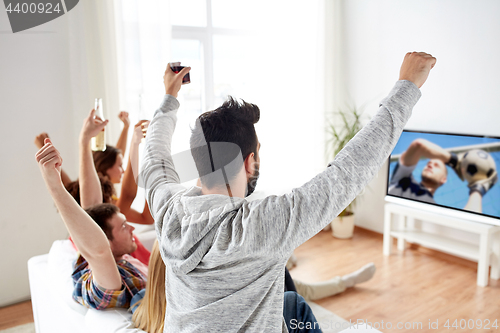 Image of friends watching football or soccer game on tv