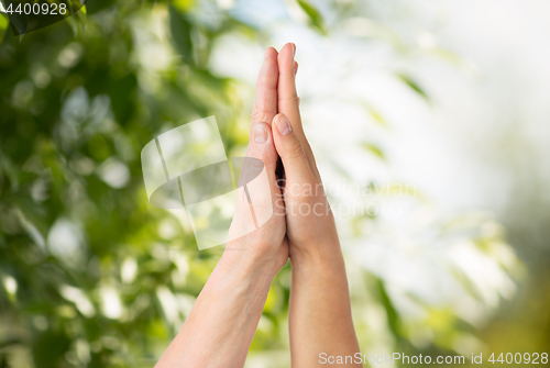 Image of close up of senior and young woman touching hands