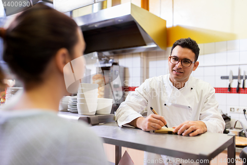 Image of chef at fast food restaurant writing order