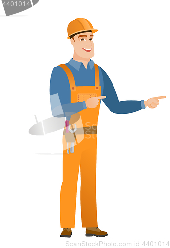 Image of Young caucasian builder pointing to the side.