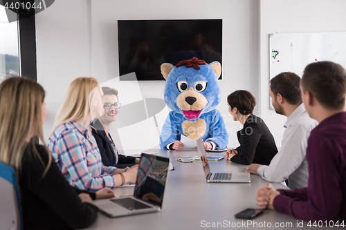 Image of boss dresed as bear having fun with business people in trendy of