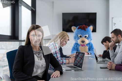 Image of boss dresed as bear having fun with business people in trendy of