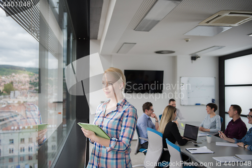 Image of Pretty Businesswoman Using Tablet In Office Building by window