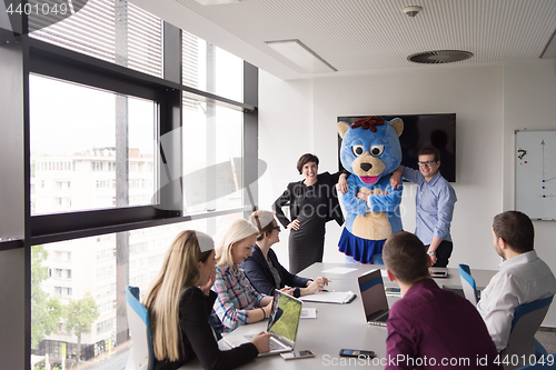 Image of boss dresed as bear having fun with business people in trendy of