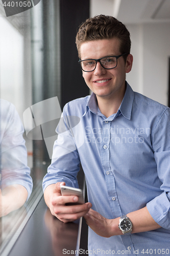 Image of Businessman Standing In A Modern Building Near The Window With P