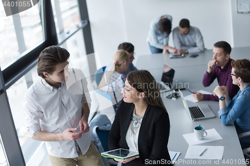 Image of Two Business People Working With Tablet in office