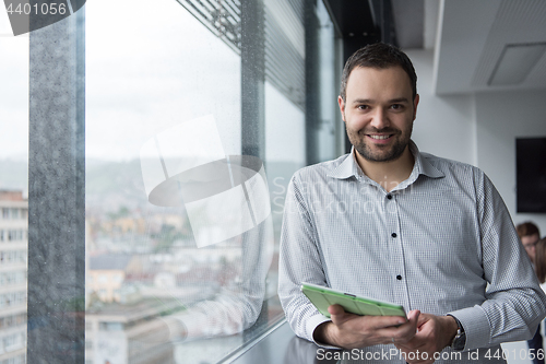 Image of Businessman Using Tablet In Office Building by window