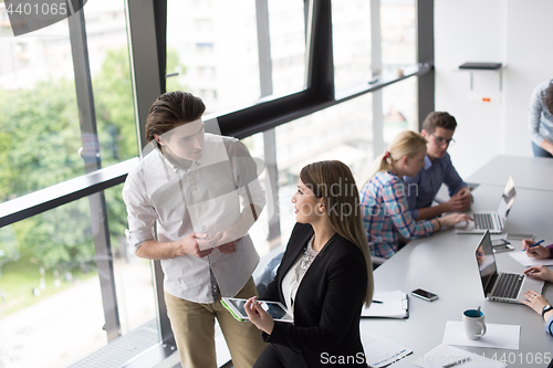 Image of Two Business People Working With Tablet in office