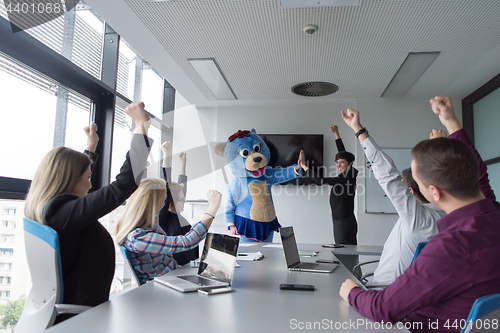 Image of boss dresed as bear having fun with business people in trendy of