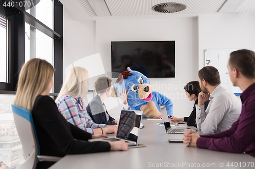 Image of boss dresed as bear having fun with business people in trendy of