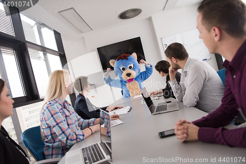 Image of boss dresed as bear having fun with business people in trendy of