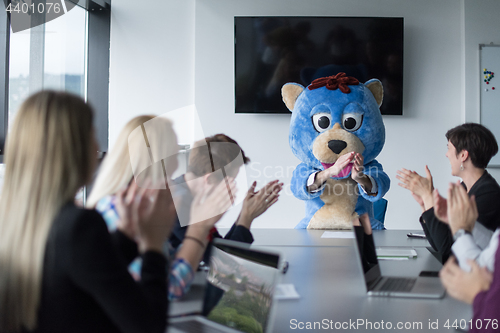 Image of boss dresed as bear having fun with business people in trendy of