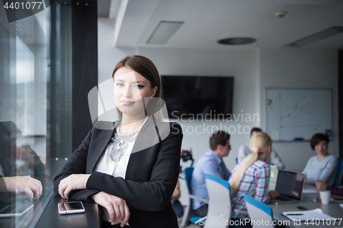 Image of Elegant Woman Using Mobile Phone by window in office building