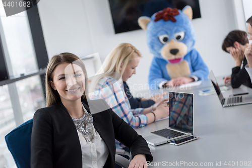 Image of boss dresed as bear having fun with business people in trendy of