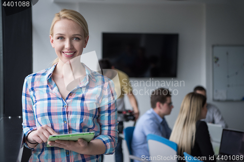 Image of Pretty Businesswoman Using Tablet In Office Building by window