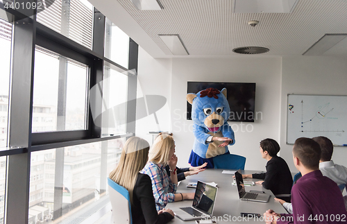 Image of boss dresed as bear having fun with business people in trendy of