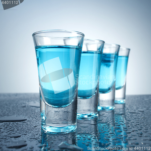 Image of Vodka glass with ice on blue background