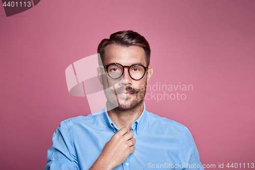 Image of Portrait of a handsome young happy man over pink background