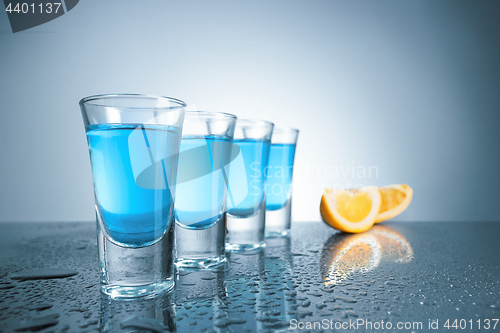 Image of Vodka glass with ice on blue background