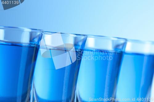 Image of Vodka glass with ice on blue background