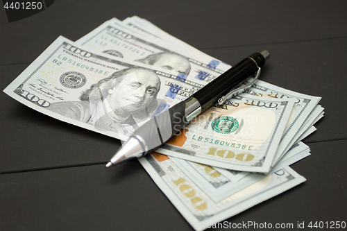 Image of Heap of money and pen. Writer fee