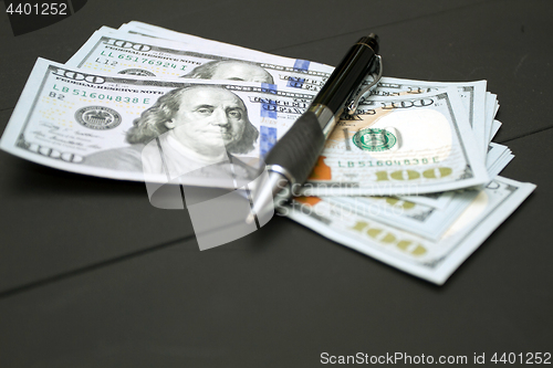 Image of Heap of money and pen. Writer fee