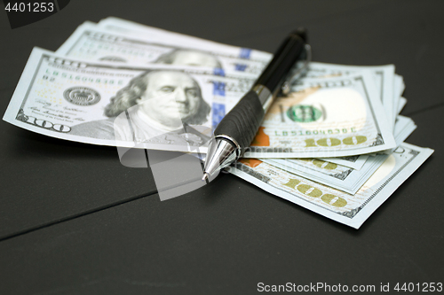 Image of Heap of money and pen. Writer fee