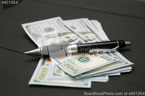 Image of Heap of money and pen. Writer fee