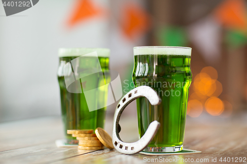 Image of glass of green beer, horseshoe and gold coins