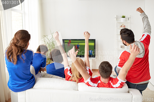 Image of football fans watching soccer game on tv at home
