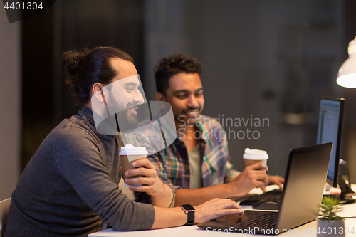 Image of creative team drinking coffee at night office