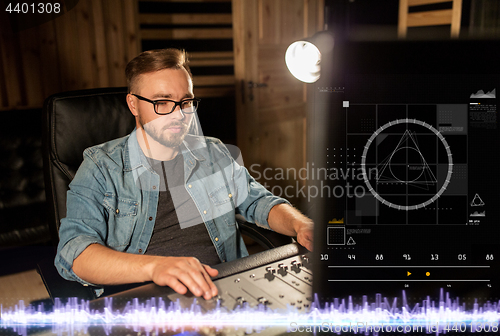 Image of man at mixing console in music recording studio