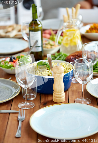 Image of pepper mill or salt grinder on table with food