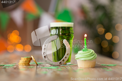 Image of glass of beer, cupcake, horseshoe and gold coins