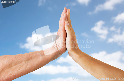 Image of close up of senior and young woman hands over sky