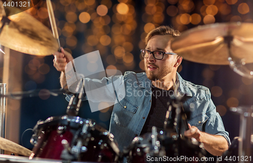 Image of male musician playing drums and cymbals at concert