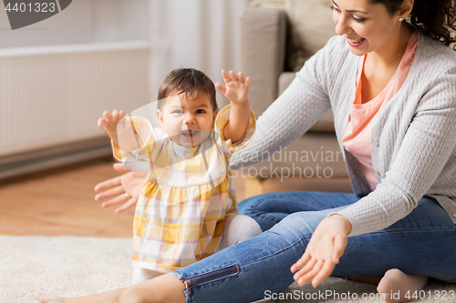 Image of happy smiling mother with baby daughter at home