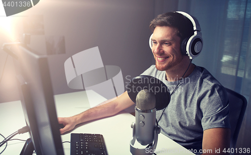 Image of man in headset playing computer video game at home