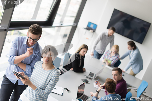 Image of Two Business People Working With Tablet in office