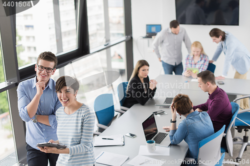 Image of Two Business People Working With Tablet in office