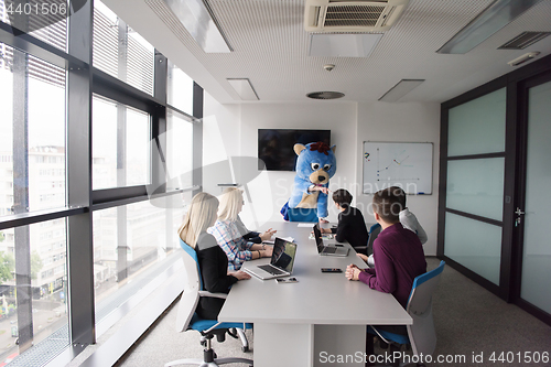 Image of boss dresed as bear having fun with business people in trendy of