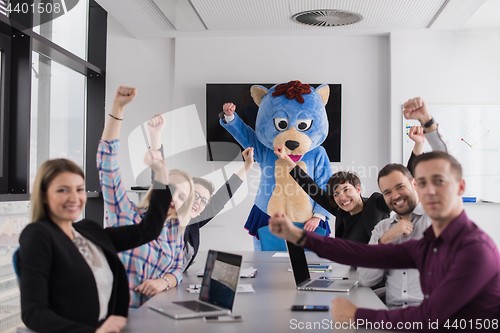 Image of boss dresed as bear having fun with business people in trendy of