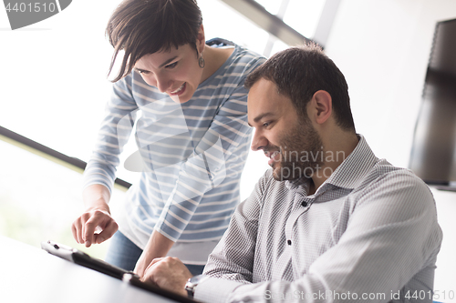 Image of Two Business People Working With Tablet in startup office