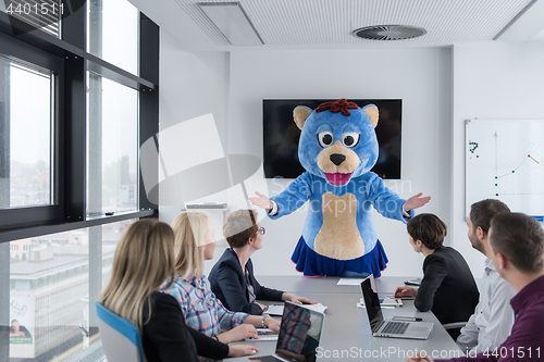 Image of boss dresed as bear having fun with business people in trendy of