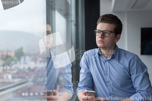 Image of Businessman Standing In A Modern Building Near The Window With P