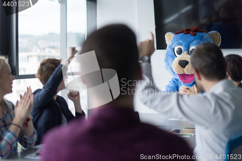 Image of boss dresed as bear having fun with business people in trendy of