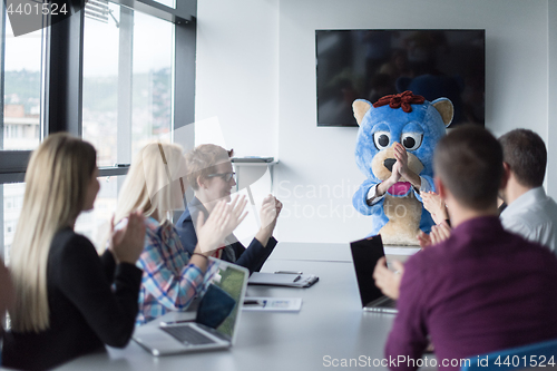 Image of boss dresed as bear having fun with business people in trendy of